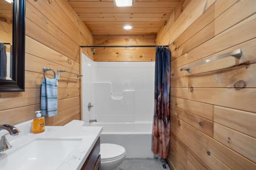 a bathroom with a toilet and a tub and a sink at Barndominium at Paradise Pointe in Bryant