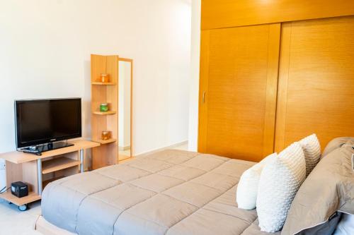 a bedroom with a bed and a flat screen tv at Punta Piedra By Andiani in Cancún