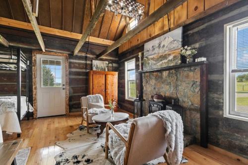 a living room with a fireplace and wooden walls at The Prairie House Retreat in Mentone