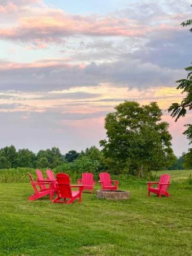a group of red chairs sitting in a field at The Prairie House Retreat in Mentone