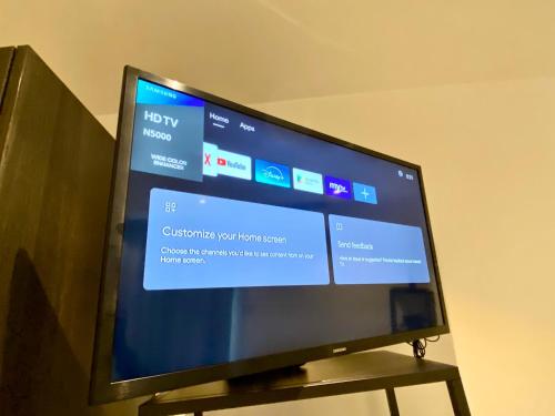 a flat screen tv sitting on a wooden stand at APARTMENTS GH - Accra - Cantonments - Embassy Gardens in Accra