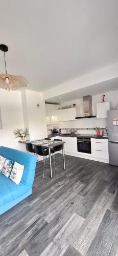 une cuisine avec un canapé bleu et une table dans l'établissement Appartement studio O fil de l'O à 12 kilomètres de Disneyland Paris, à Crécy-la-Chapelle