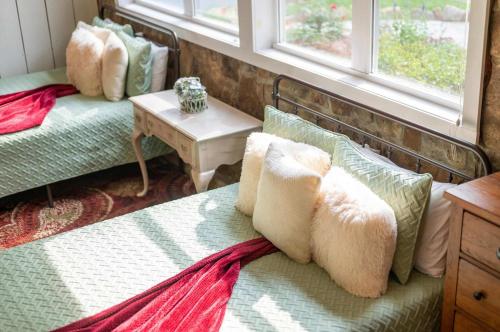 a bedroom with a bed and a table and windows at Cragsmere Manor - Luxury Estate & Event Space in Mentone