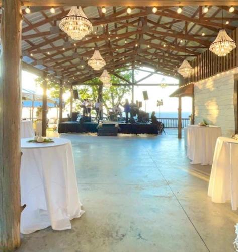 a banquet hall with white tables and chandeliers at Cragsmere Manor - Luxury Estate & Event Space in Mentone