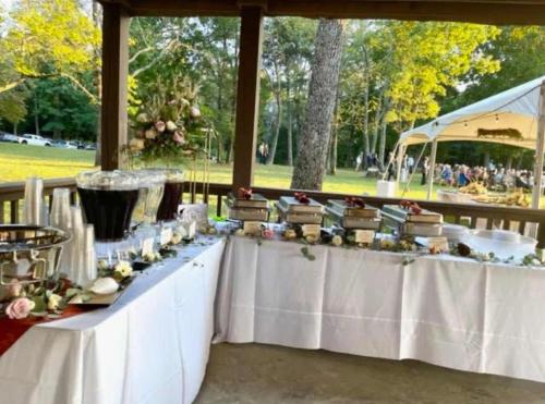 a long table with white tables and flowers on it at Cragsmere Manor - Luxury Estate & Event Space in Mentone