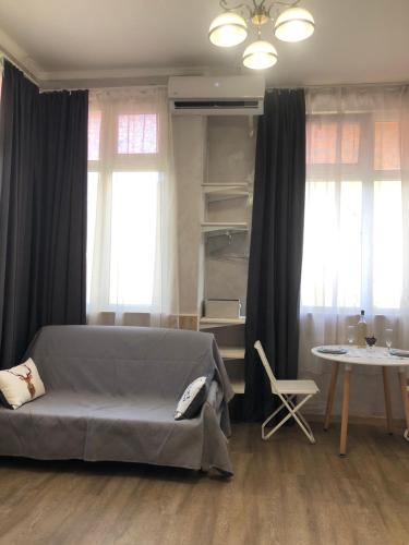a bedroom with a bed and a table and windows at Lucky Space 1 Nice&Cosy Studio in Budva