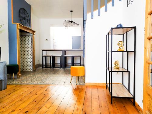 un salon avec une chaise jaune et des étagères dans l'établissement La Manutention de Saint-Omer, à Saint-Omer