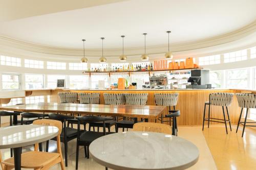 a restaurant with tables and chairs and a counter at Kenmore Village Hotel, South Beach in Miami Beach