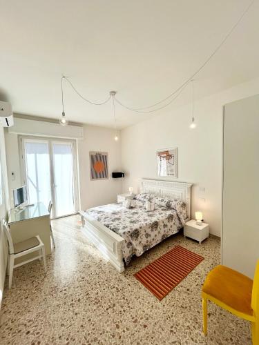 a large white bedroom with a bed and a chair at Alloggio Primavera Matilde in Terni