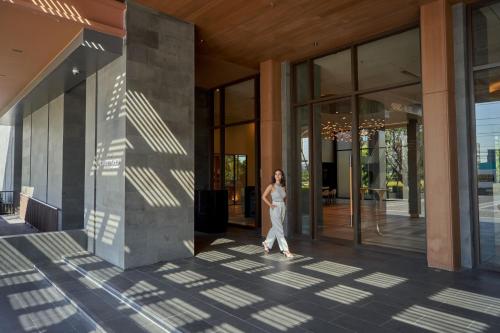 a woman walking out of a building at Courtyard by Marriott Bangkok Suvarnabhumi Airport in Lat Krabang