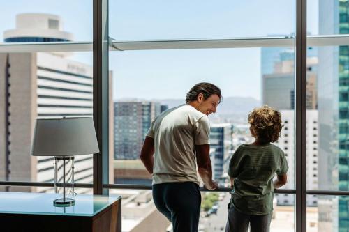 a man and a child looking out of a window at The Westin Phoenix Downtown in Phoenix