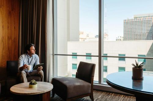 a man sitting in a room looking out the window at The Westin Phoenix Downtown in Phoenix
