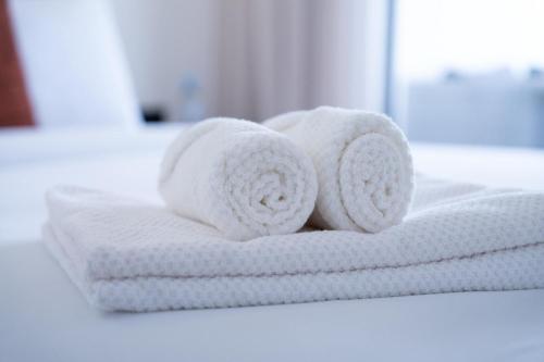a stack of white towels on a bathroom counter at Appartement avec Piscine dans Résidence Privée in Dar Bouazza