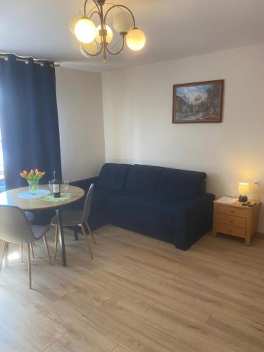 a living room with a blue couch and a table at Apartament Mączyńskiego 4 in Jarosław
