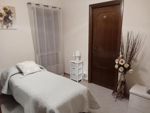 a bedroom with a bed and a vase of flowers at La Mora in Castelvecchio Calvisio