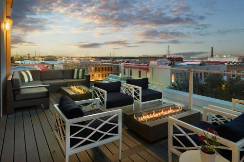 a balcony with a couch and chairs and a fire place at The Tremont House, Galveston, a Tribute Portfolio Hotel in Galveston