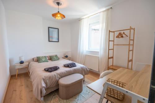 una camera da letto con un letto, un tavolo e una finestra di La Villa des Oliviers - Les Demeures d 'Adrien a Valenciennes