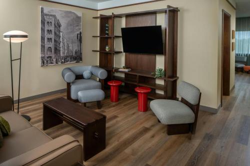 a living room with a couch and a flat screen tv at The Tallison Hotel, a Tribute Portfolio Hotel in Carmel