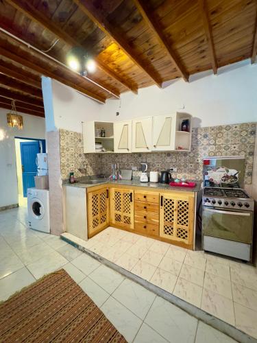 a kitchen with wooden cabinets and a stove at Blue Villa in Lighthouse in Dahab