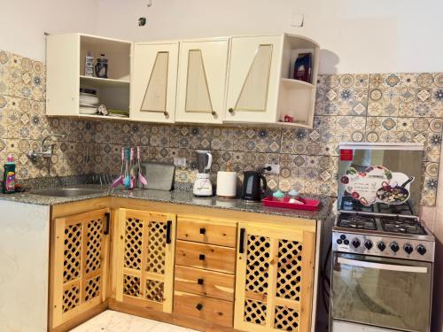 a kitchen with white cabinets and a sink and a stove at Blue Villa in Lighthouse in Dahab