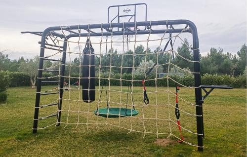 a batting cage with a net in a field at Amazing Home In Kakma With Sauna in Kakma