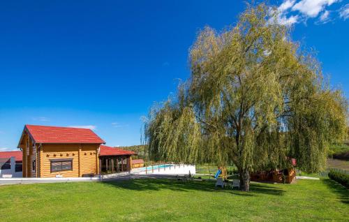 a large tree in front of a wooden house at Amazing Home In Petrinja With Wi-Fi in Petrinja