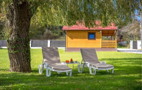 two chairs and a table in front of a tree at Amazing Home In Petrinja With Wi-Fi in Petrinja