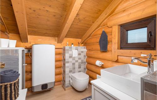 a bathroom with a toilet and a sink in a log cabin at Amazing Home In Petrinja With Wi-Fi in Petrinja