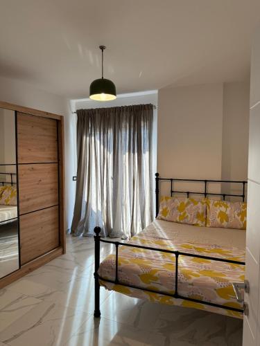 a bedroom with a bed and a window at Shengjin Apartment on the beach in Shëngjin