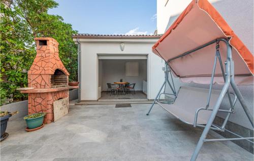 a backyard with a bed and a pizza oven at Lovely Apartment In Povljana With Wifi in Povljana