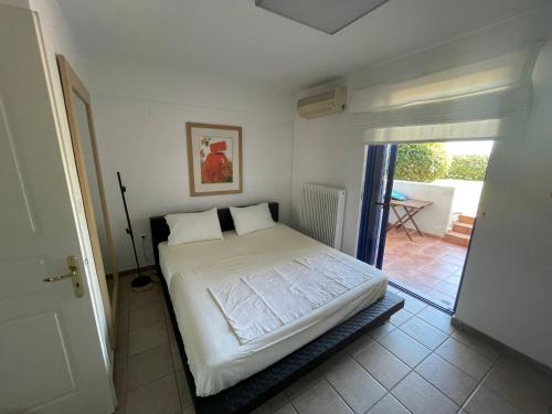 a bedroom with a bed and a door to a patio at Maisonette by the sea in Melission