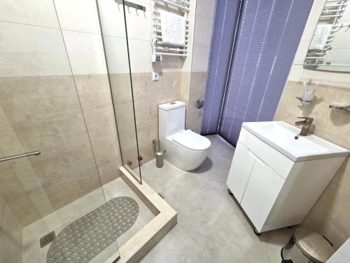 a bathroom with a toilet and a shower and a sink at Hotel Ere's Palace in Tbilisi City