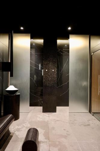 a bathroom with a shower and a bench in a room at Luksusowy apartament Infinity Chill Baltic Spa in Międzyzdroje