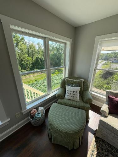 a living room with a chair and two windows at 1878 RiverRun B&B - Waterfront, Self-Serve Breakfast, WiFi, Trail and River access in Hancock