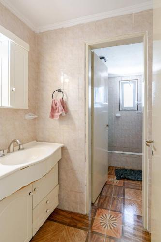 a bathroom with a sink and a shower at Casa familiar para 7 con Parrilla, Desayuno incluido y A 5 min Piedra Movediza in Tandil