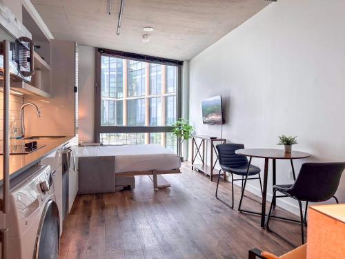 a kitchen with a bed and a table with chairs at River View Suite - The Wharf DC by Monthier in Washington, D.C.