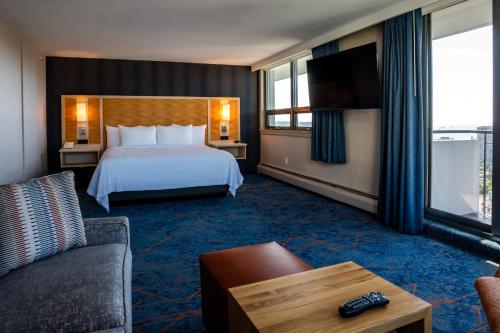 a hotel room with a bed and a couch at Blue Horizon Hotel in Vancouver