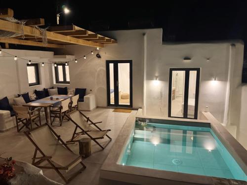 Kukulú Luxurious Cottage with Mini Private Pool في أنو ميرا: غرفة معيشة مع مسبح وطاولة وكراسي