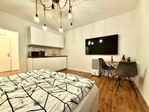 a bedroom with a bed and a table and a tv at The Hill Studio - Free Parking & Walk to Old Town in Vinohrady