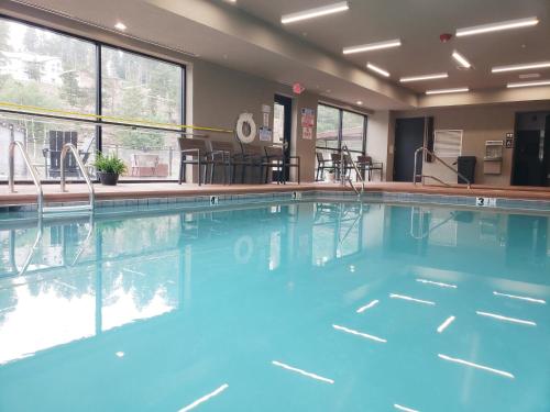 a swimming pool with blue water in a building at Grand Cloudcroft Hotel in Cloudcroft