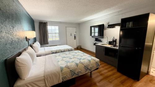 a hotel room with two beds and a kitchen at Studio 6 Beaumont, TX in Beaumont