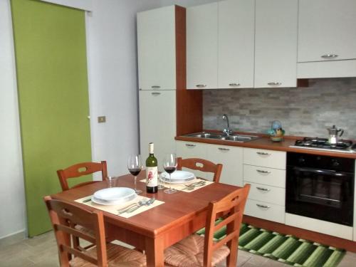 カステッランマーレ・デル・ゴルフォにあるCarpe Diem Apartmentsのキッチン(木製テーブル、椅子2脚付)