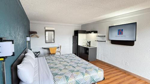 a hotel room with a bed and a flat screen tv at Studio 6 Beaumont, TX in Beaumont