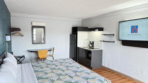 a hotel room with a bed and a flat screen tv at Studio 6 Beaumont, TX in Beaumont