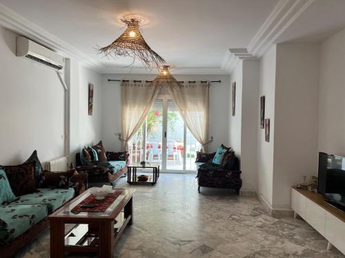 a living room with a couch and a table at Dar Chado, Charming and Spacious in Hammamet Nord