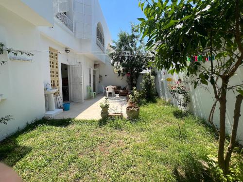 a courtyard of a white house with a yard at Dar Chado, Charming and Spacious in Hammamet Nord