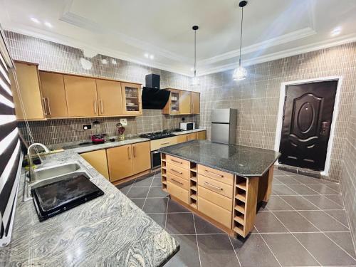 cocina grande con armarios de madera y encimera negra en Go flex homes, en Ikuata