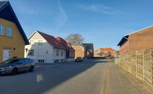 a street with houses and a car on the road at Private apartment near Billund in Grindsted