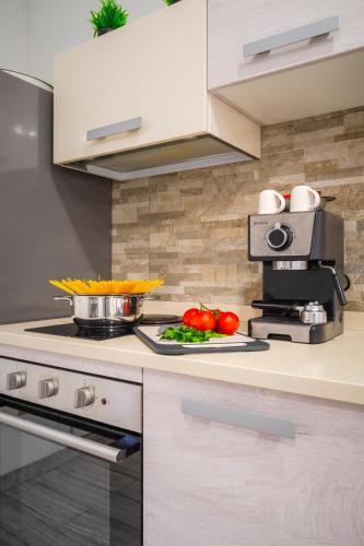 a kitchen with a stove and vegetables on a counter at Casa Antonietta - relax a Macerata in Macerata
