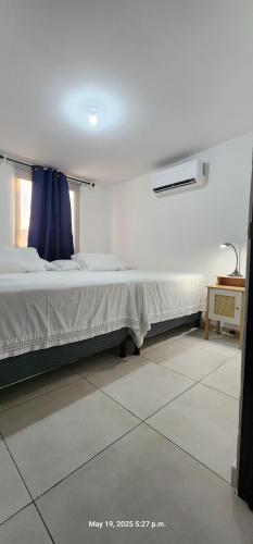 a bedroom with a bed with a blue curtain at La Joya de Opico in San Juan Opico